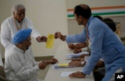 Mantan perdana menteri India Manmohan Singh, sorban biru, bersiap untuk memberikan suaranya untuk pemilihan presiden partai kongres, di New Delhi, Senin, 17 Oktober 2022. (AP/Manish Swarup)
