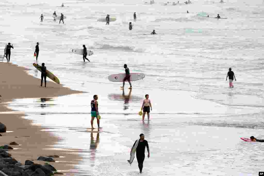 Surfers are seen on the beach at the Basque coast in Biarritz, southwestern France. The hot weather is expected to last for several days across the country.