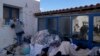 A volunteer adjusts the supplies for the migrants at an old school used as a temporary shelter on the island of Kythira, southern Greece, Oct. 7, 2022. Rescue efforts were in place at two Greek islands after shipwrecks. 