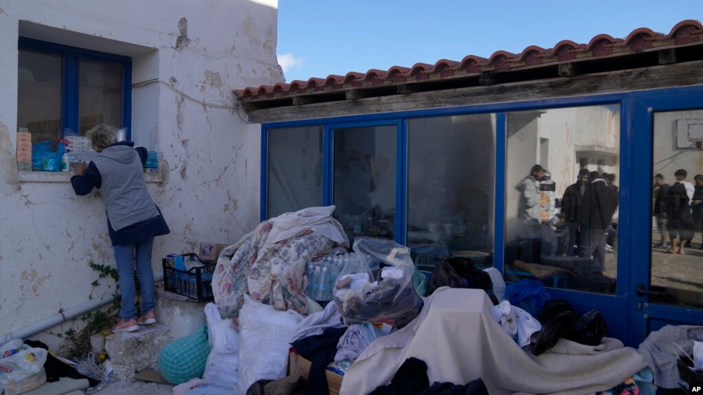 A volunteer adjusts the supplies for the migrants at an old school used as a temporary shelter on the island of Kythira, southern Greece, Oct. 7, 2022. Rescue efforts were in place at two Greek islands after shipwrecks. 