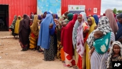FILE - Somali women and children who left rural areas due to drought receive nutritional assistance at a camp for the internally displaced, on the outskirts of Baidoa, Somalia, Oct. 12, 2022.