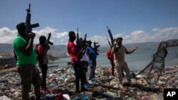 FILE - Armed men are seen near the perimeter wall that encloses the currently blockaded Terminal Varreux, in Port-au-Prince, Haiti, Oct. 6, 2021.