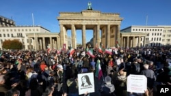 FILE - People gather in front of the Brandenburg Gate in Berlin, Oct. 7, 2022 to protest against the government in Iran in memory of Mahsa Amini, a young Iranian woman who died after being arrested in Tehran by Iran's 'morality police'. 