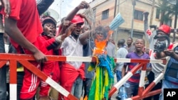 Sejumlah warga membakar bendera Rwanda dalam aksi protes di Goma, Republik Demokratik Kongo, pada 30 Oktober 2022. (Foto: AP/Justin Katumwa)