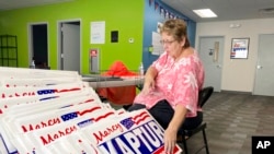 FILE - Carol Discher, a volunteer for the reelection campaign for Rep. Marcy Kaptur, D-Ohio, stacks yard signs in Toledo, Ohio, Sept. 17, 2022.