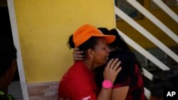 Magaly Colmenares cries as the body of her seven-year-old grandson Angel Senprum is brought to a community health center in Las Tejerias, Venezuela, Oct. 10, 2022.