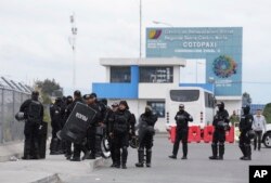 Polisi dengan perlengkapan anti huru hara berkumpul di luar penjara setelah kerusuhan mematikan di penjara di Latacunga, Ekuador, Selasa, 4 Oktober 2022. Bentrokan antara narapidana bersenjatakan pistol dan pisau di dalam penjara telah menewaskan sedikitnya 15 orang dan 20 orang luka-luka. (Foto AP/Dolores Ochoa)