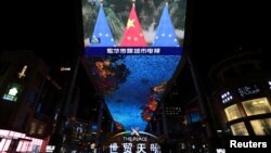 FILE - A giant screen shows news footage of Chinese national and European Union flags during an EU-China virtual summit, in Beijing, China, April 1, 2022.