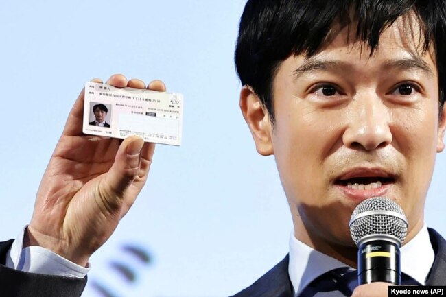 Japanese actor Masato Sakai shows a sample of My Number card during a promotional event in Tokyo on March 8, 2021. (Kyodo News via AP)