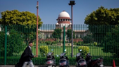 Seorang pengacara berjalan di depan gedung Mahkamah Agung menjelang vonis larangan hijab, di New Delhi, India, Kamis, 13 Oktober 2022. (AP/Altaf Qadri)