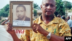 Un Guinéen tient le portrait d'une des victimes de la dictature d'Ahmed Sékou Touré, le 3 octobre 2008 à Conakry, en Guinée.