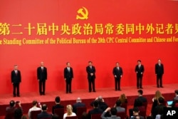 FILE - New members of the Politburo Standing Committee, from left, Li Xi, Cai Qi, Zhao Leji, President Xi Jinping, Li Qiang, Wang Huning and Ding Xuexiang are introduced at the Great Hall of the People in Beijing, 23 October , 2022.