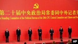 New members of the Politburo Standing Committee, from left, Li Xi, Cai Qi, Zhao Leji, President Xi Jinping, Li Qiang, Wang Huning, and Ding Xuexiang are introduced at the Great Hall of the People in Beijing, Oct. 23, 2022. 