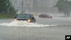 One motorist drives though high water as another turns around during the effects of Hurricane Ian, Sept. 30, 2022, in Charleston, S.C.