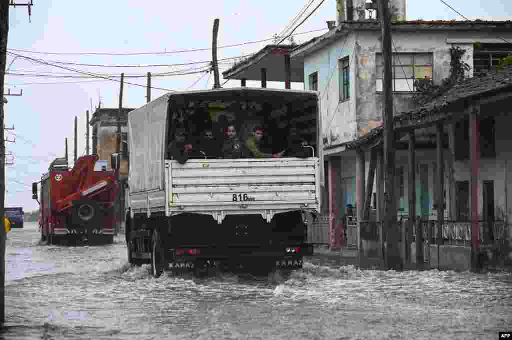 Un camión que transporta miembros del ejército pasa por una calle inundada en Batabanó, Cuba, el 27 de septiembre de 2022, durante el paso del huracán Ian.&nbsp; (Foto de YAMIL LAGE / AFP)