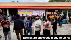 People gather outside of a daycare center, a scene of a mass shooting in the town of Uthai Sawan, 500 km (310 miles) northeast of Bangkok in the province of Nong Bua Lamphu, Thailand, Oct. 6, 2022