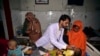 Children in hospital beds are treated after their family homes were hit by flooding in Sehwan, Sindh province, Pakistan, Sept. 9, 2022. 