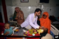 Anak-anak di ranjang rumah sakit dirawat setelah rumah mereka diterjang banjir di Sehwan, Provinsi Sindh, Pakistan, 9 September 2022. (Foto: AP)