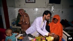 Children in hospital beds are treated after their family homes were hit by flooding in Sehwan, Sindh province, Pakistan, Sept. 9, 2022. 