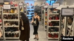 Customers look at bags displayed at a store of second-hand luxury goods platform ZZER in Shanghai, China September 9, 2022. (REUTERS/Xihao Jiang)