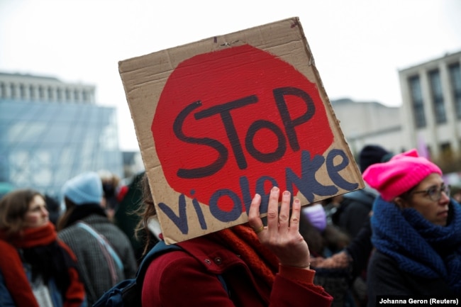 Seorang demonstran memegang plakat selama protes nasional terhadap ketidaksetaraan, kekerasan, KDRT dan pelecehan seksual terhadap perempuan di Brussels, Belgia, 28 November 2021. (Foto: REUTERS/Johanna Geron)