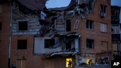People check the damage to apartments hit by a Russian missile in Mykolaiv, Oct. 23, 2022.