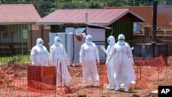 FILE - Doctors walk inside the Ebola isolation section of Mubende Regional Referral Hospital, in Mubende, Uganda, Sept. 29, 2022.