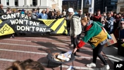 Protesters burn mock energy bills outside a venue which is to host a Conservative Party conference, in Birmingham, England, Oct. 1, 2022. 