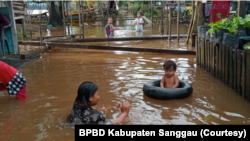 Anak-anak bermain di tengah banjir hingga 100 sentimeter di Kecamatan Kapuas Kabupaten Sanggau, Provinsi Kalimantan Barat, Jumat (7/10). (Foto: BPBD Kabupaten Sanggau)