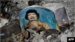 Фотография Муаммара Каддафи среди обломков здания в Сирте (архивное фото)