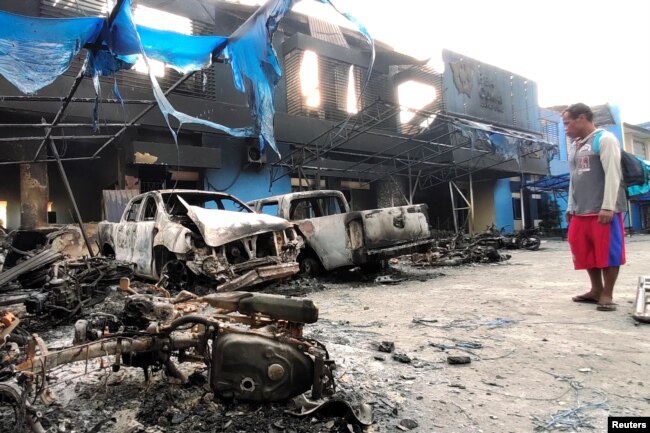 Seorang pria melihat kendaraan yang rusak di depan kantor Bea dan Cukai Indonesia setelah kerusuhan di Jayapura, Papua, 30 Agustus 2019. (Foto: Antara/Indrayadi TH via REUTERS)