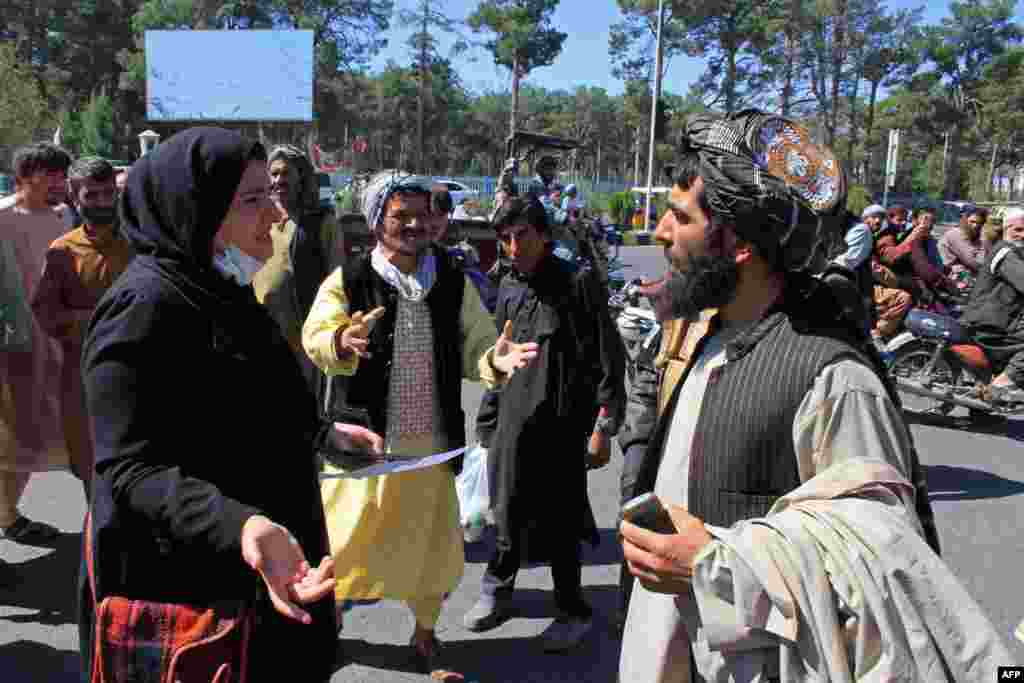 An Afghan woman speaks with a member of the Taliban during a protest in Herat.