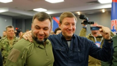 데니스 푸실린(왼쪽) 도네츠크인민공화국(DPR) 수반이 27일 밤, 러시아 병합 찬반을 묻는 주민투표의 개표 윤곽이 드러난 시점에 기자회견하며 웃고 있다. 