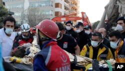 Rescue workers carry a 7-year-old girl rescued from a collapsed building in Izmir, Turkey, Oct. 31, 2020.