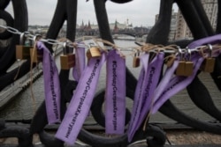 FILE - Padlocks and ribbons signed "Free for Khachaturyan sisters" are attached on the Patriarshy Bridge during an action against domestic violence, with the Kremlin in the background, in Moscow, Russia, Dec. 14, 2019.