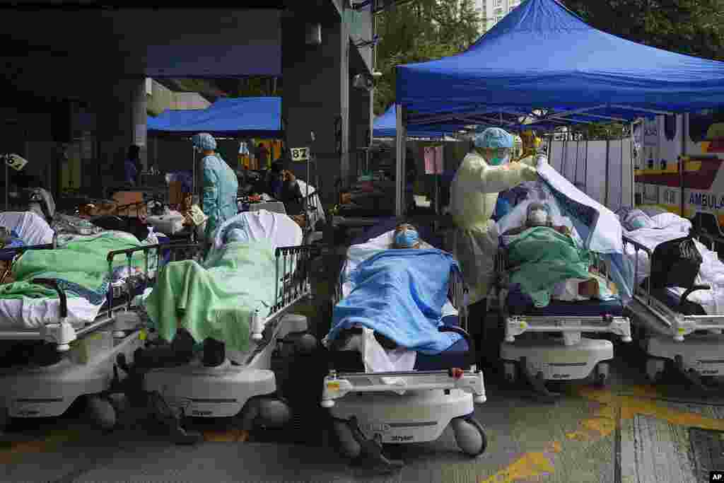 Patients lie on hospital beds as they wait at a temporary makeshift treatment area outside Caritas Medical Centre in Hong Kong, where hospitals reached 90% capacity and COVID-19 quarantine facilities were at their limit, authorities said.