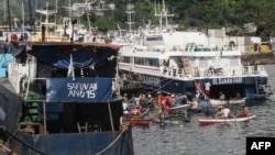 Une vue générale du port de Mutsamudu, la capitale de l'Union des Comores d'Anjouan, montre un pêcheur en attente de bateaux arrivant le 21 mars 2018.