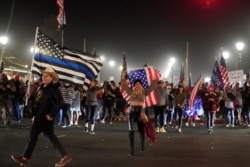 Manifestantes marchan por la autopista Pacific Coast, en Huntington Beach, California, el sábado 21 de noviembre, durante una protesta contra órdenes estatales que restringen las actividades nocturnas por un repunte del coronavirus.