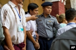 Reuters journalist Kyaw Soe Oo, center, is escorted by police as they leave the court, April 4, 2018, Yangon, Myanmar.