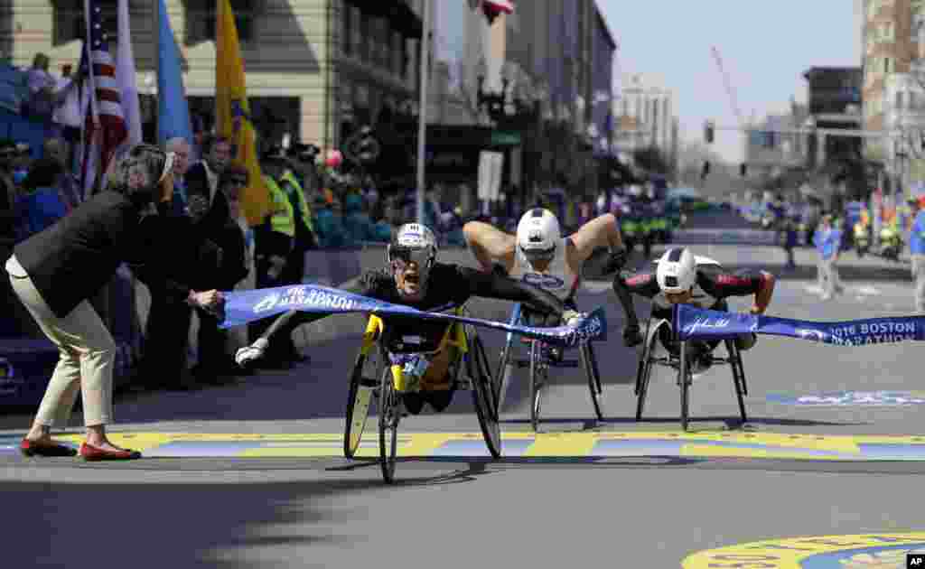 Marcel Hug, of Switzerland, breaks the tape ahead of Kurt Fearnley, of Australia, center, and Ernst Van Dyk, of South Africa, in the wheelchair division of the 120th Boston Marathon in Boston, Massachusetts, USA.