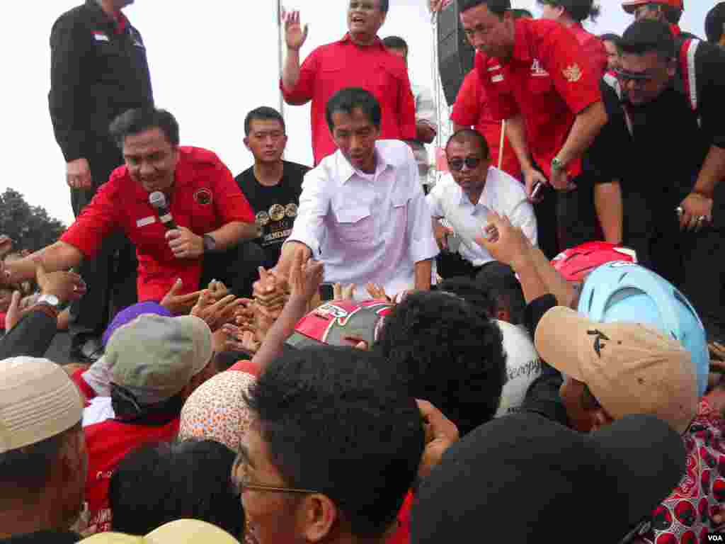 Calon presiden dari Partai Demokrasi Indonesia Perjuangan, Gubernur Jakarta Joko Widodo alias Jokowi, menyalami para pendukung dalam kampanye terbuka Minggu (16/3) di Lapangan Gelanggang Olah Raga Cendrawasih, Cengkareng, Jakarta Barat. (VOA/Andylala Waluyo)