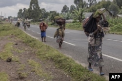 FILE - Displaced people who fled clashes between the Congolese army and M23 rebels try to return to their homes in Kibumba, in eastern Democratic Republic of Congo, on June 1, 2022.