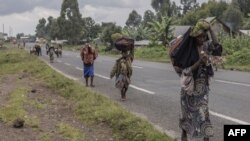 Displaced people who fled clashes between the Congolese army and M23 rebels try to return to their homes in Kibumba, in eastern Democratic Republic of Congo, on June 1, 2022. 