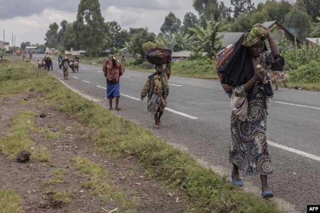 FILE - Displaced people who fled clashes between the Congolese army and M23 rebels try to return to their homes in Kibumba, in eastern Democratic Republic of Congo, on June 1, 2022.