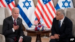 အမေရိကန်သမ္မတ Joe Biden (ဝဲ) အစ္စရေးအိမ်စောင့်အစိုးရ ဝန်ကြီးချုပ် Yair Lapid တို့ အစ္စရေးနိုင်ငံ၊ ဂျေရုစလင်မှာ တွေ့ဆုံစဉ်။ (ဇူလိုင် ၁၄၊ ၂၀၂၂)  