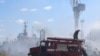 Petugas pemadam kebakaran Ukraina berusaha memadamkan api pada kapal yang terbakar di pelabuhan Odesa, Ukraina, setelah serangan misil menghantam area pelabuhan pada 23 Juli 2022. (Foto: Odessa City Council/AFP)