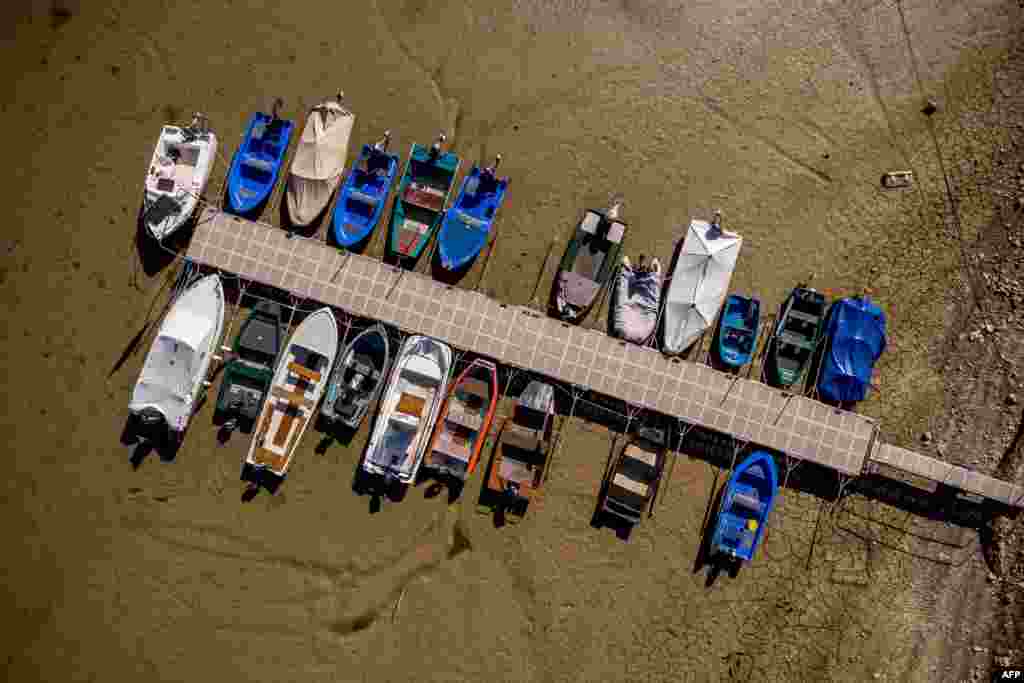 An aerial view shows boats in the dry bed of Brenets Lake (Lac des Brenets), part of the Doubs River, a natural border between eastern France and western Switzerland, in Les Brenets.