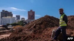 Un ouvrier regarde une mine d'or précédemment opérationnelle en cours de réhabilitation dans la banlieue de Johannesburg le 14 avril 2022.