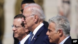 Presidenti Biden përkrah Presidentit izraelit Isaac Herzog (majtas) dhe Kryeministrit izraelit Yair Lapid (djathtas), në aeroportin Ben Gurion (13 korrik 2022)