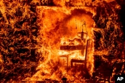 Flames engulf a chair inside a burning home as the Oak Fire burns in Mariposa County, Calif., July 23, 2022.